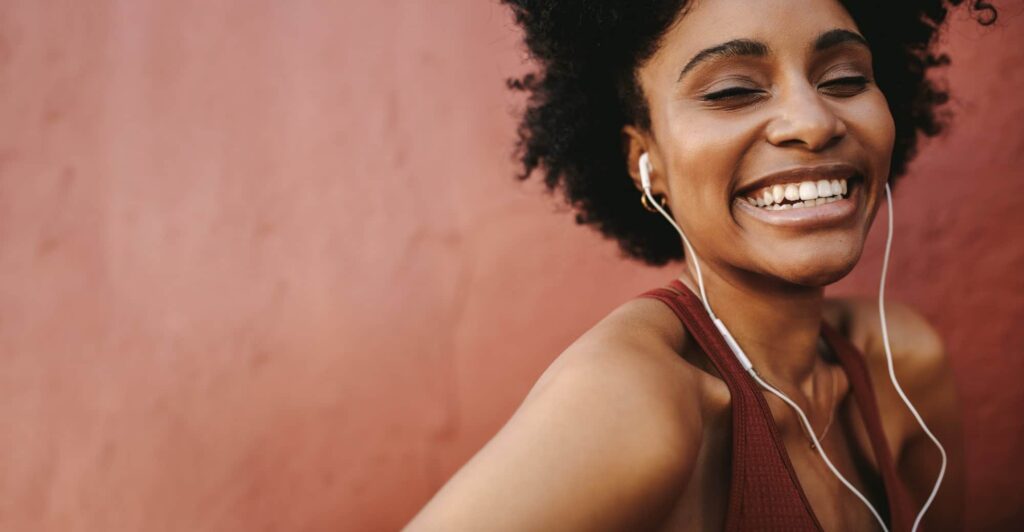 Woman smiling at camera wearing headphones