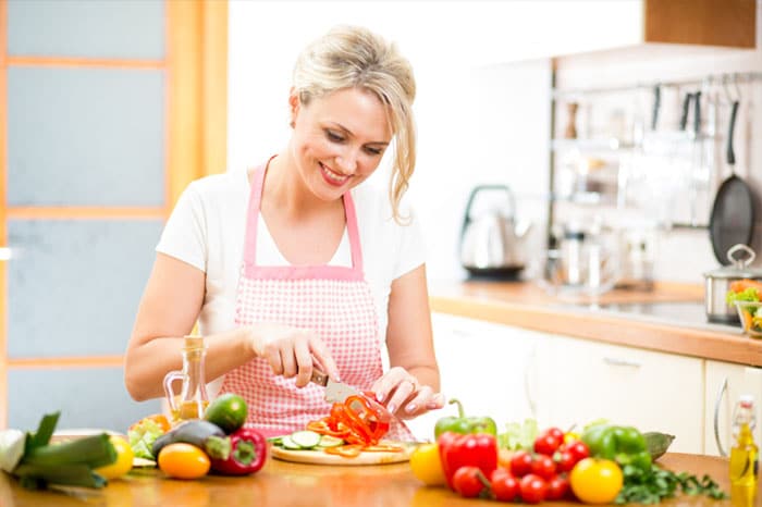 Female cooking healthy foods to reach her weight loss goals